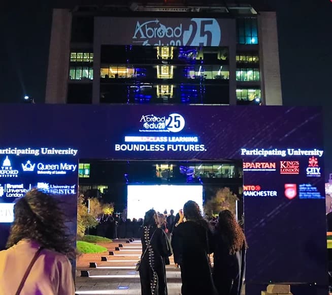 Abroad Events — Guests walking toward an illuminated event entrance at night